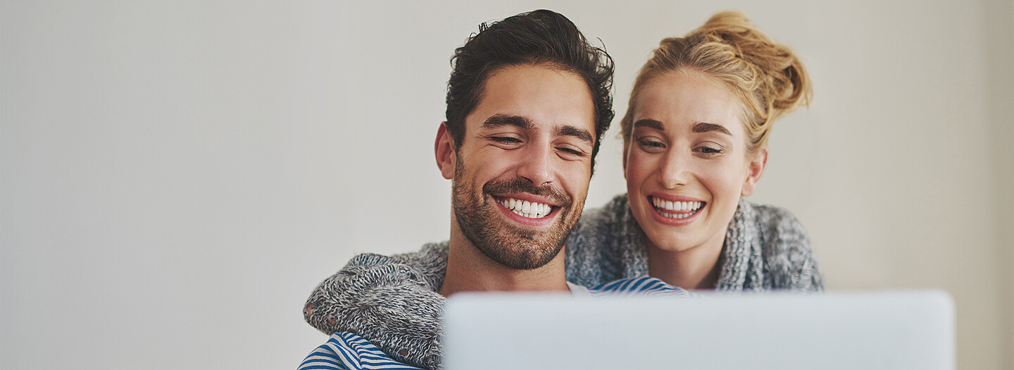 Junges Paar vor Laptop bei der Anmeldung ins BayernLabo Serviceportal zur Verwaltung Ihrer Förderanträge.