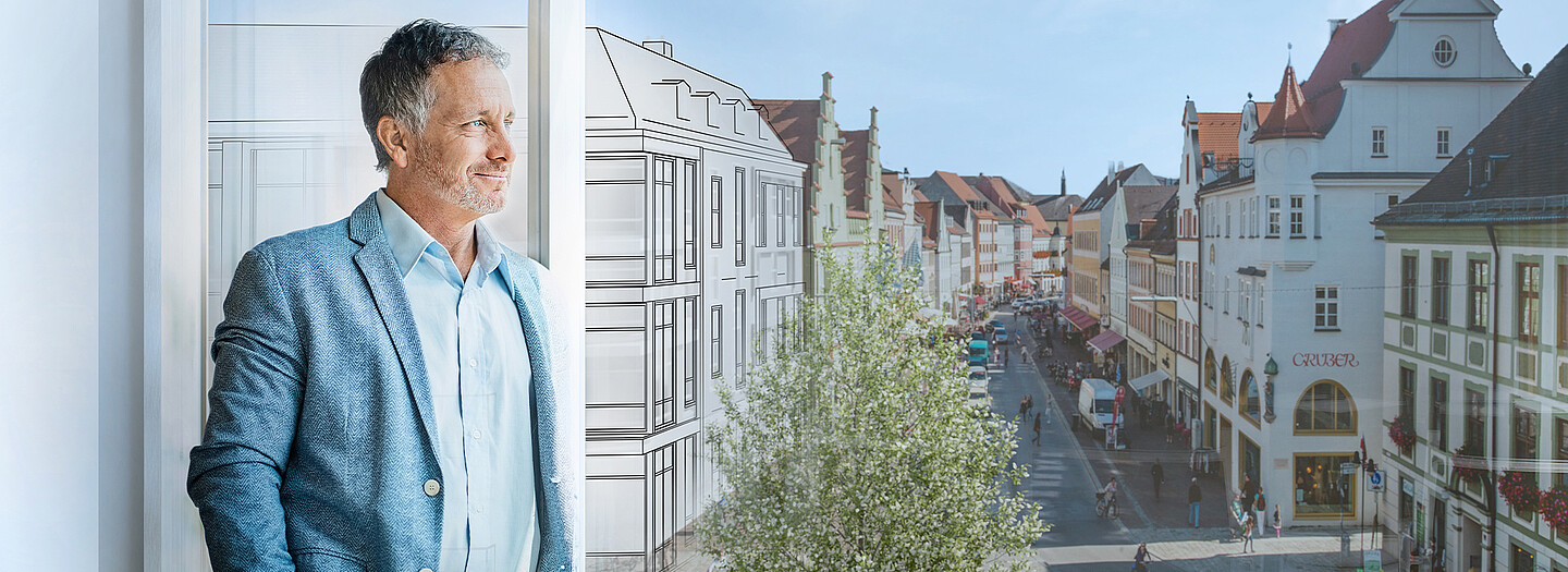 Gestalten Sie die Zukunft Ihrer Kommune mit der Unterstützung der BayernLabo Bürgermeister blickt au dem Fenster auf seine Kommune unterstützt durch die BayernLabo.